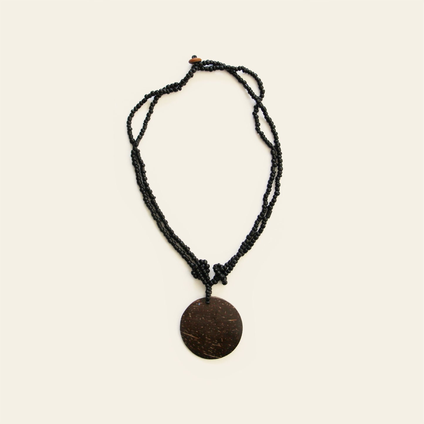 Handmade necklace with coconut shell pendant and black seed beads