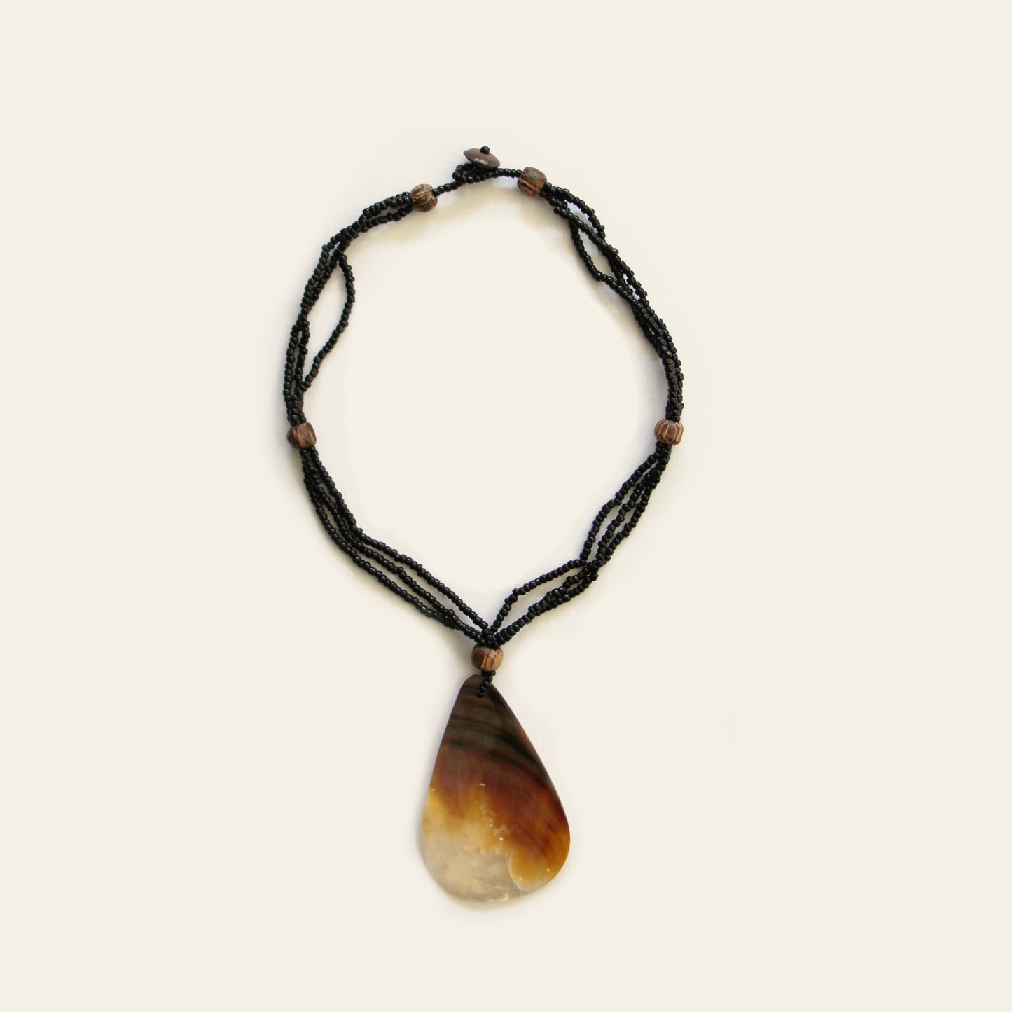 Full view of teardrop-shaped mother-of-pearl pendant necklace with black seed beads and wooden accents – Nayabijou.
