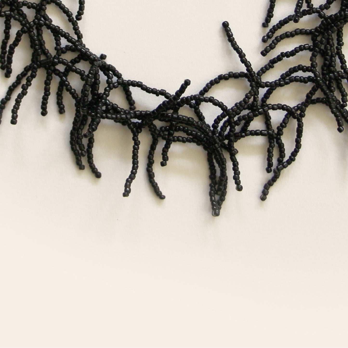 Close-up of black seed beads forming coral-like fringe design