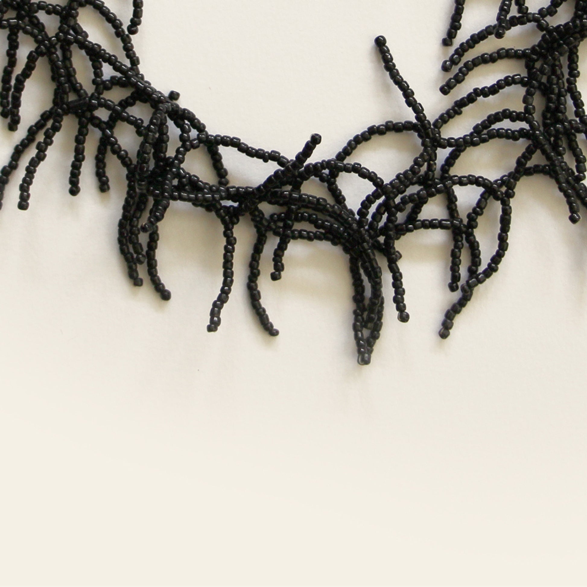 Close-up of black seed beads forming coral-like fringe design