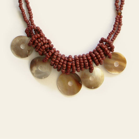 Close-up of burgundy seed bead necklace with circular mother-of-pearl discs – Nayabijou.