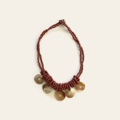 Full view of layered burgundy beaded necklace with round mother-of-pearl disc pendants – Nayabijou.