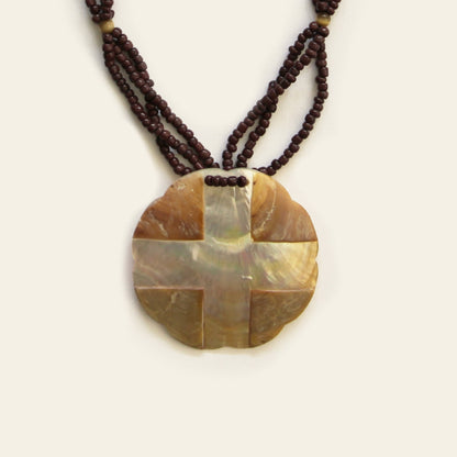 Closeup of warm-toned mother of pearl pendant necklace with dark brown seed bead strands – Nayabijou