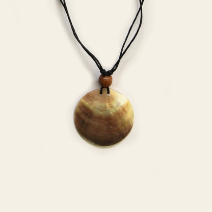 Closeup of handmade necklace with black cord and round natural Mother of Pearl pendant – Nayabijou.