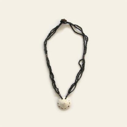 Handmade necklace with layered black seed beads and a white natural shell pendant — Nayabijou.