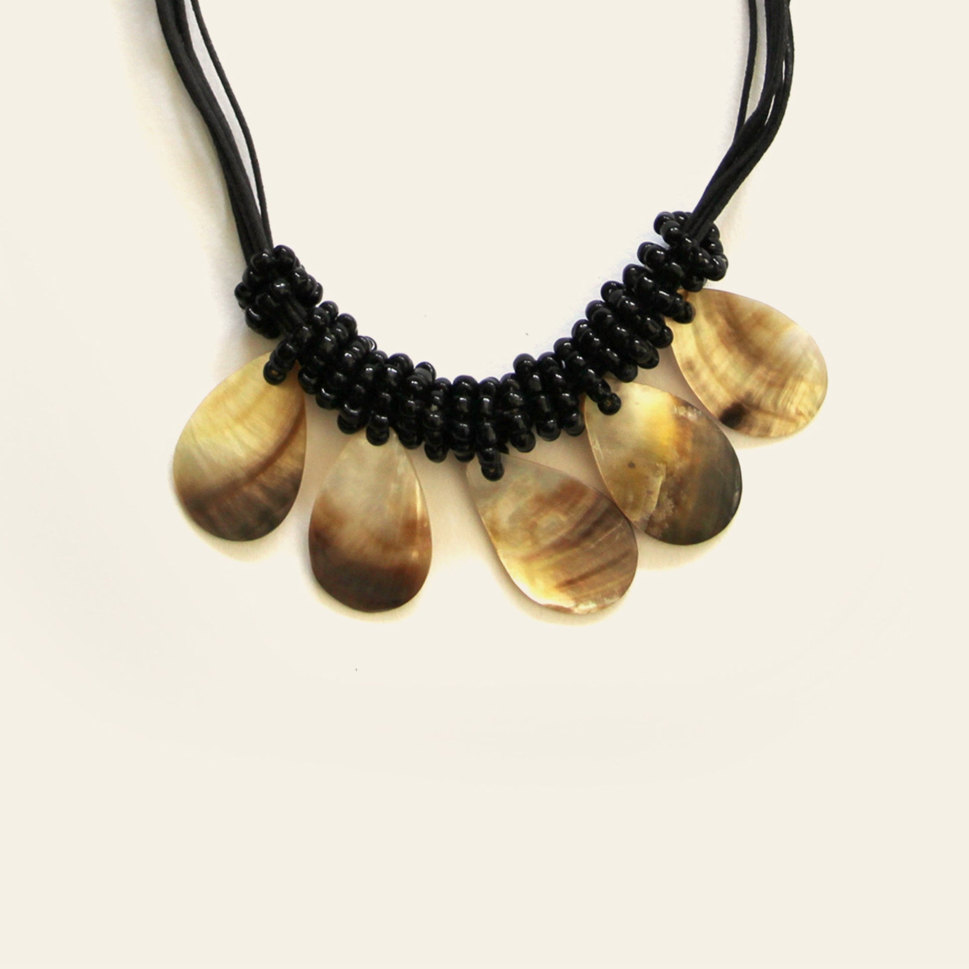 Closeup of black teardrop shell necklace with multi-cord detail and handcrafted finish- Nayabijou