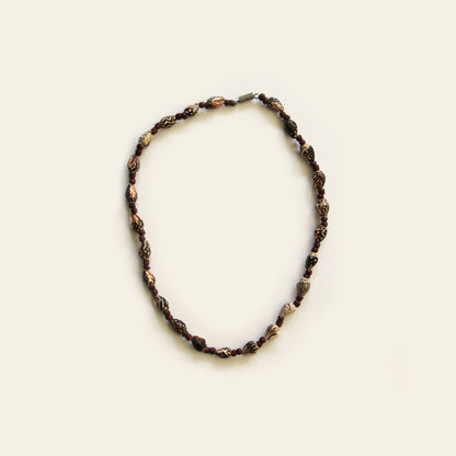 Handmade necklace with carved brown beads, small shell accents, and warm brown seed beads — by Nayabijou.