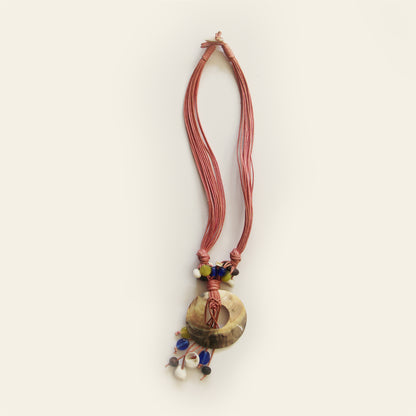 Handmade necklace with mauve cords, a round shell pendant, and colorful natural beads – by Nayabijou.