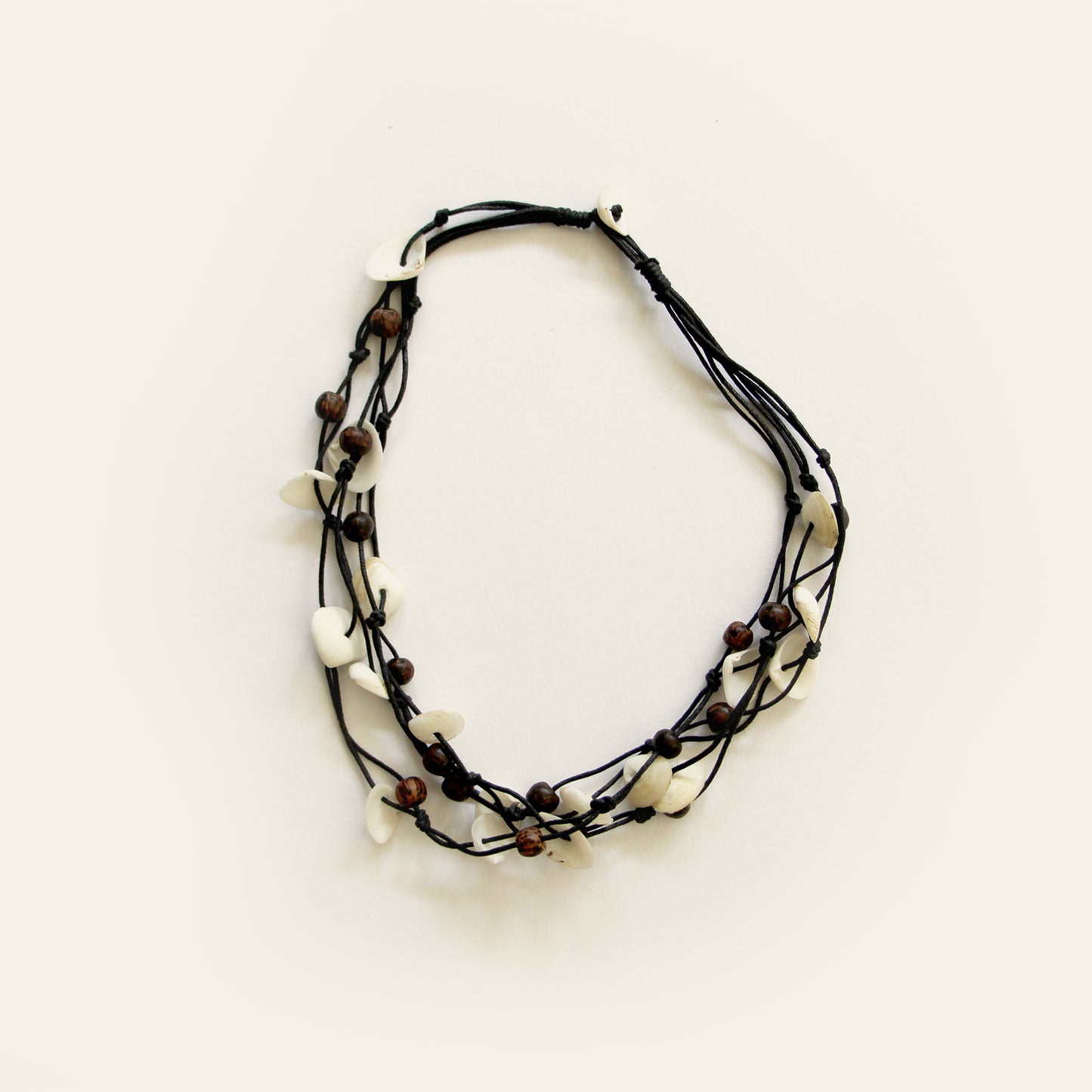 Handmade black cotton thread necklace with layered white shell pieces and dark wooden beads — Nayabijou.