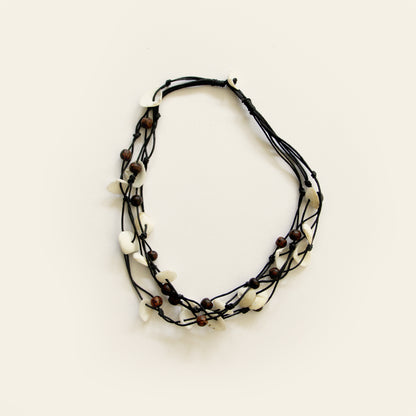 Handmade black cotton thread necklace with layered white shell pieces and dark wooden beads — Nayabijou.