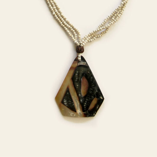 Closeup of handmade necklace with triangular mother of pearl shell pendant and beaded strands – Nayabijou.