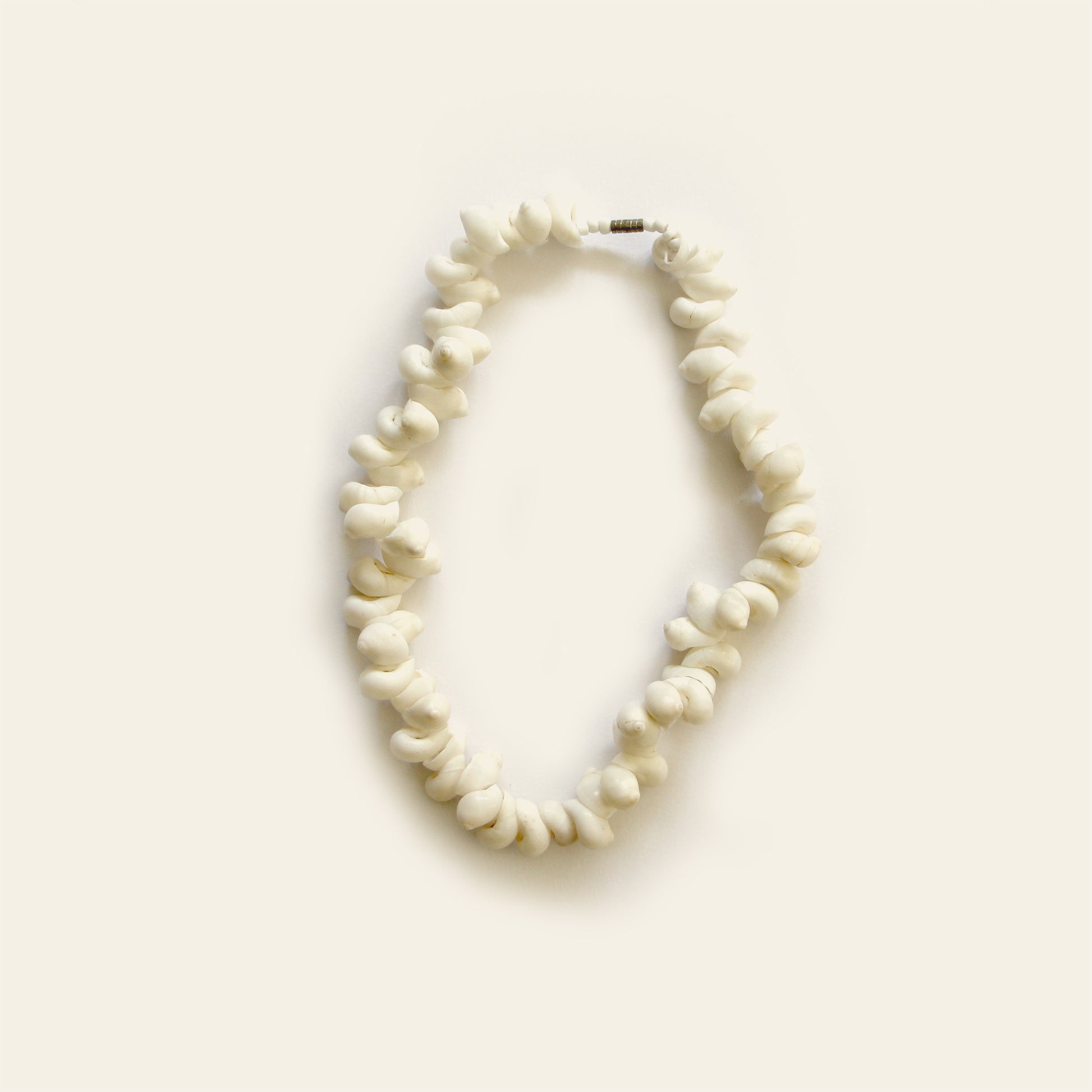 Handmade bracelet made of white twisted shell beads strung tightly in a natural loop — by Nayabijou.