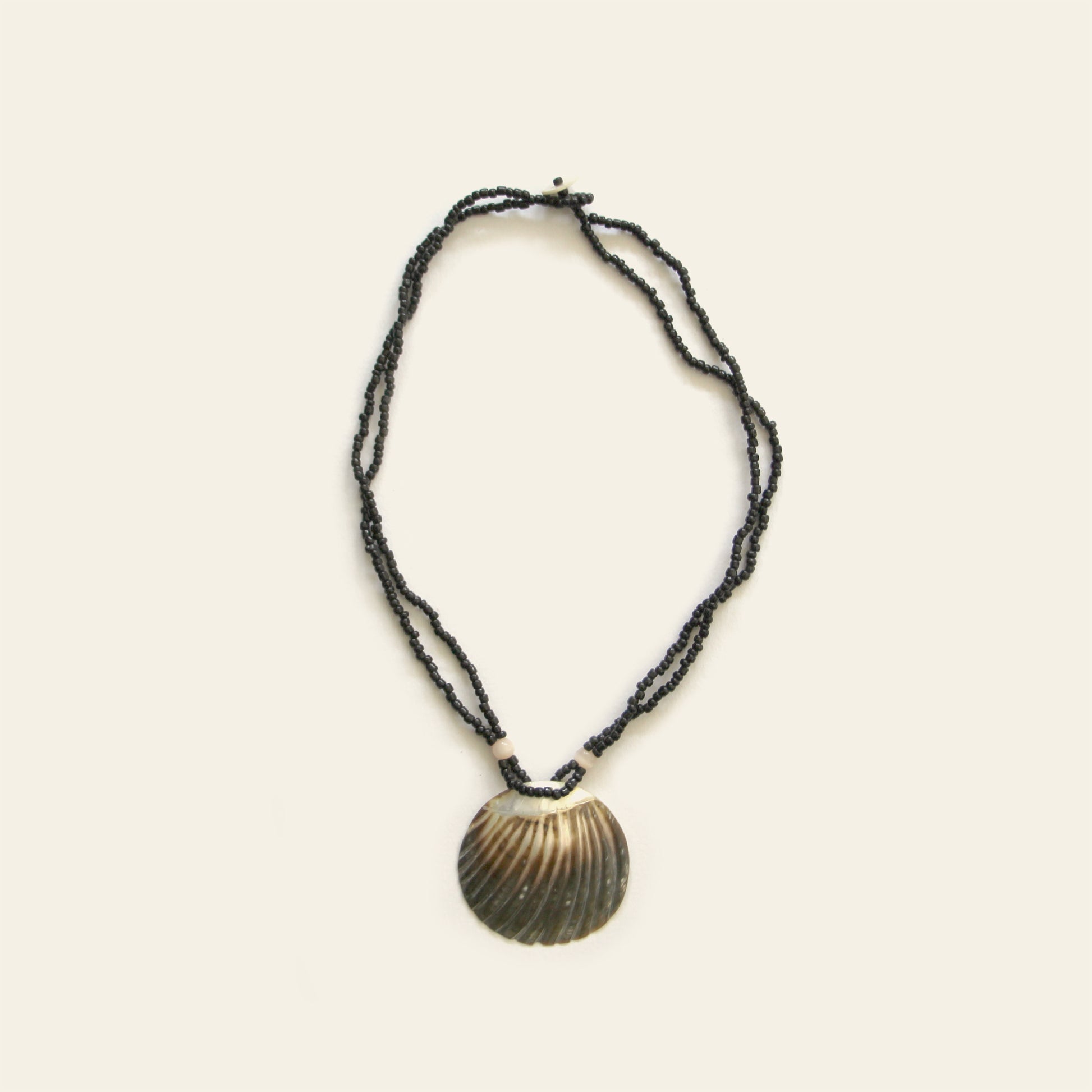 Handmade necklace with black seed beads and a dark scallop shell pendant – Nayabijou.