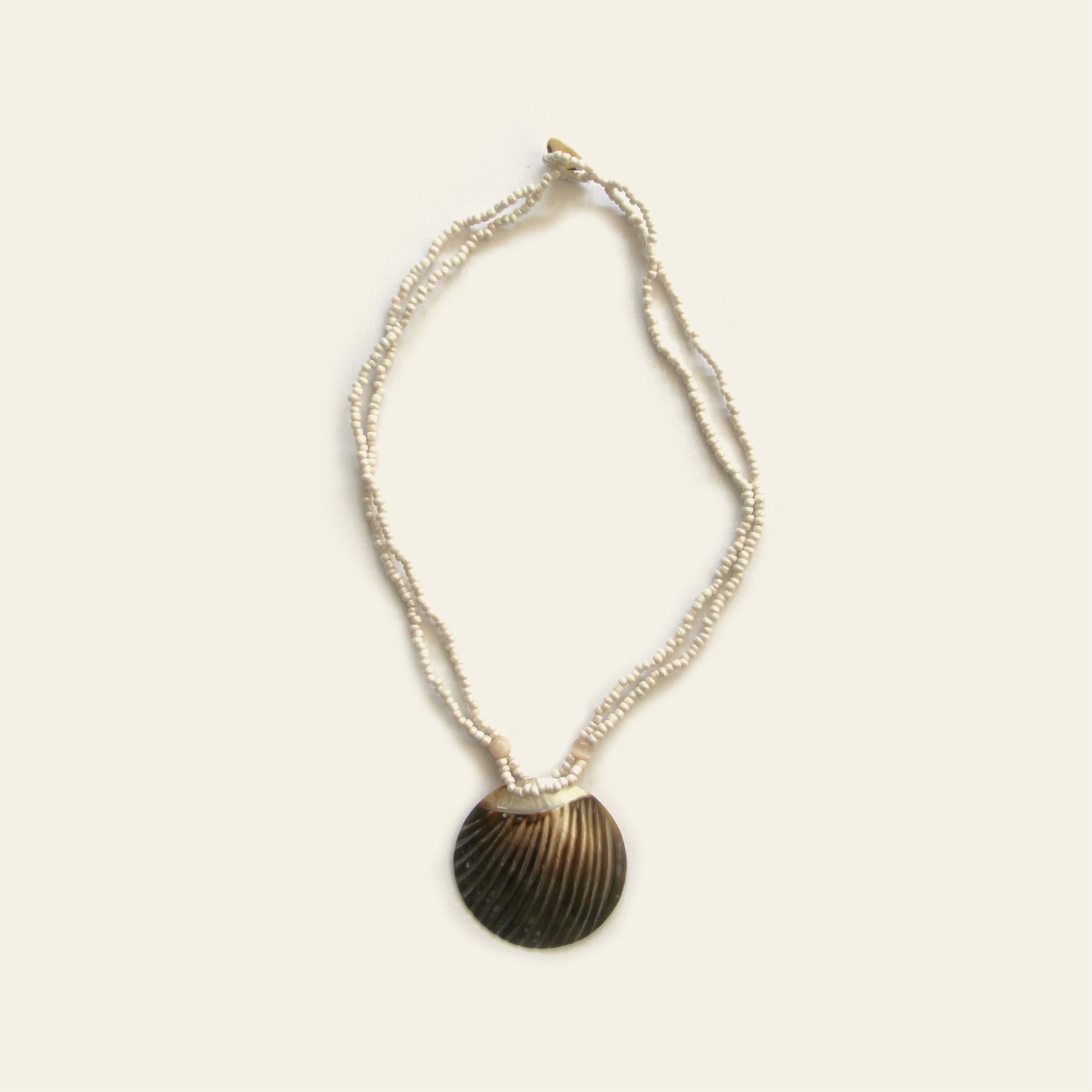 Handmade necklace with white seed beads and a dark scallop shell pendant – Nayabijou.