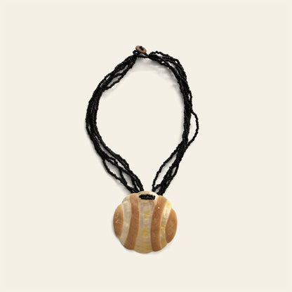 Handmade black beaded necklace with round Mother of Pearl pendant featuring wave-like beige patterns – Nayabijou.