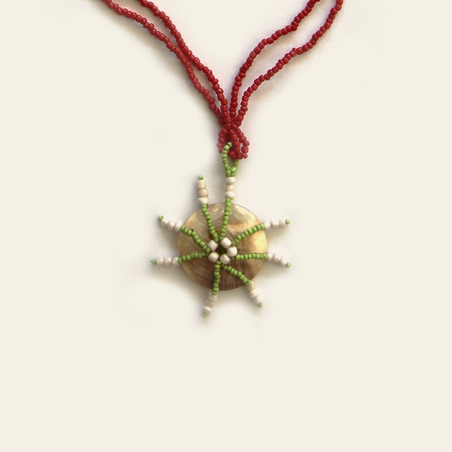 Close-up of handcrafted mother of pearl pendant with starburst bead design