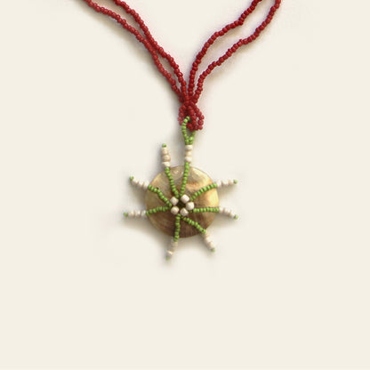 Close-up of handcrafted mother of pearl pendant with starburst bead design