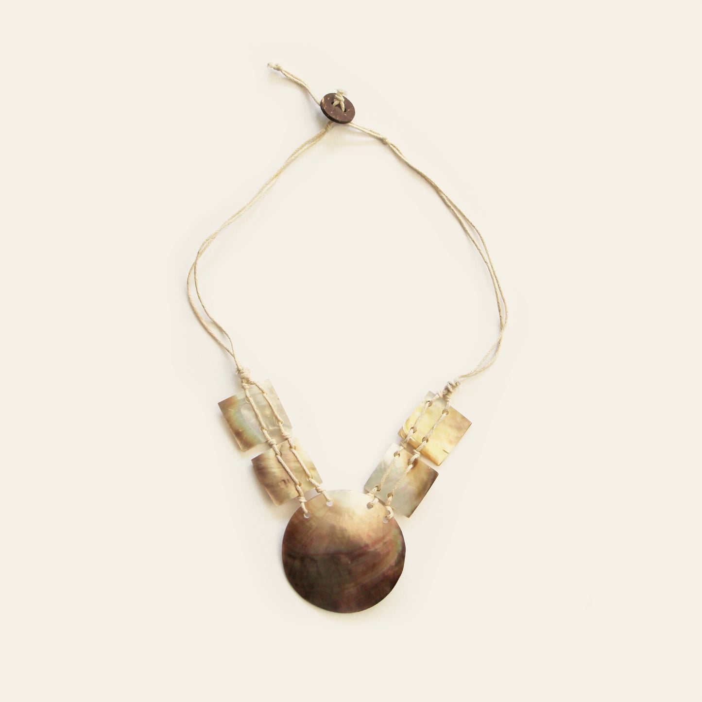 Full view of mother-of-pearl mosaic shell necklace with round and square pendants on beige cord – Nayabijou.