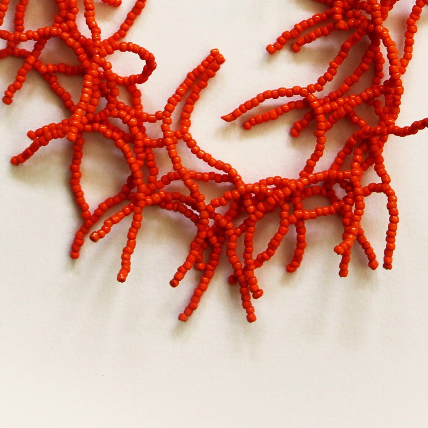 Close-up of red beaded coral-style branches showing intricate handcrafted detail